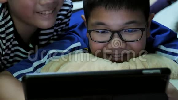 慢动作4K快乐的亚洲预科生微笑着看着平板电脑视频的预览图