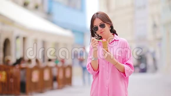 在户外吃冰淇淋筒的小女孩夏季概念热天带甜冰淇淋的女人视频的预览图