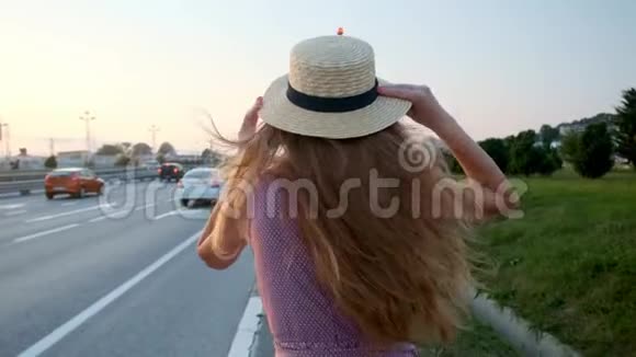 女孩带着手提箱上路在高速公路和很多车附近视频的预览图