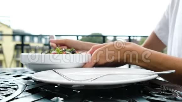 女人把黄瓜和西红柿的蔬菜沙拉放在盘子里视频的预览图