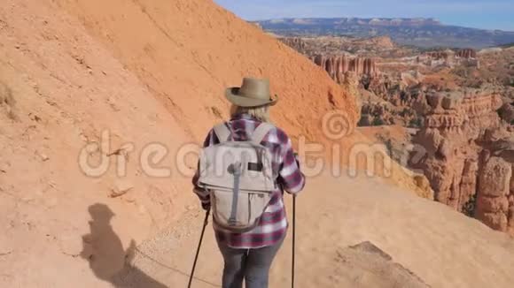 美国犹他州布莱斯峡谷的岩石边缘有个徒步旅行者的女人视频的预览图