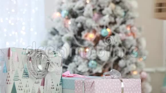 圣诞树和花环背景上的圣诞礼物和纸板屋视频的预览图