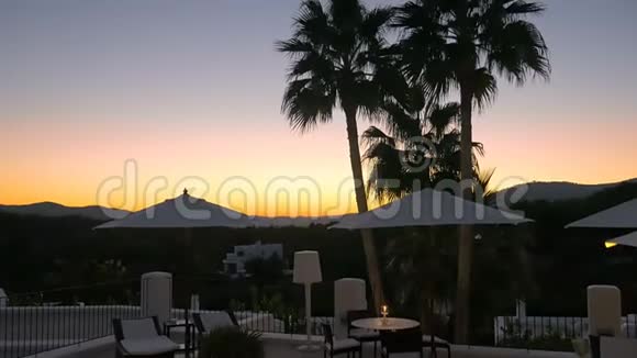 豪华酒店的精彩日落有棕榈树雨伞和蜡烛晚上在温泉度假胜地放松完美的休息视频的预览图