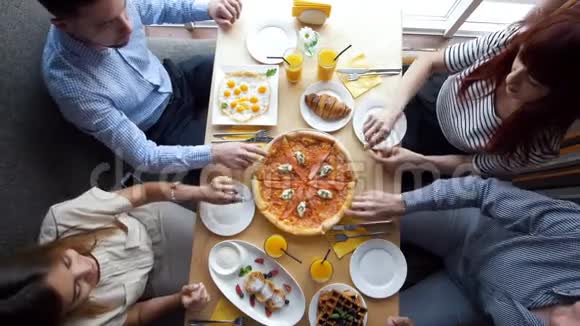 年轻的朋友在餐馆里吃盘子里的披萨视频的预览图