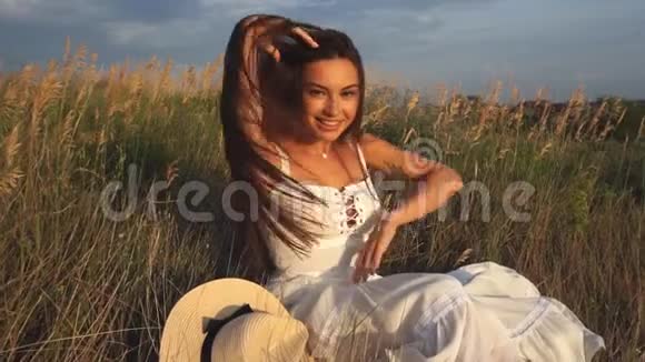 田野里一个美丽的黑发女人躺在草地上笑着视频的预览图