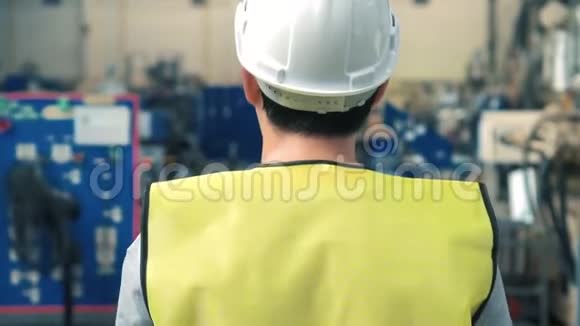 在工业设施中行走的工人戴安全安全帽视频的预览图