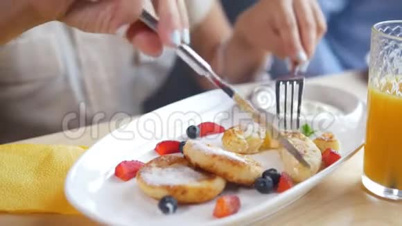 女性用手切一个美味的奶酪薄煎饼用刀叉在餐馆里视频的预览图