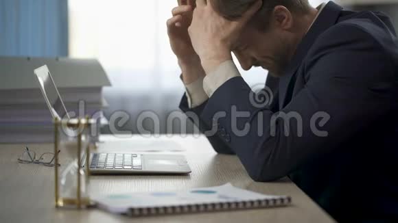 一个人坐在办公桌前脸很痛头掉在桌子上很疲劳视频的预览图