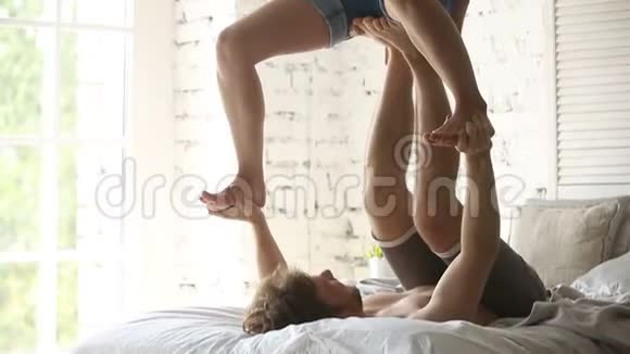 运动情侣在家玩杂技瑜伽练习视频的预览图