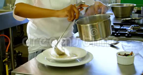 女厨师用钢包把汤倒入盘子里视频的预览图