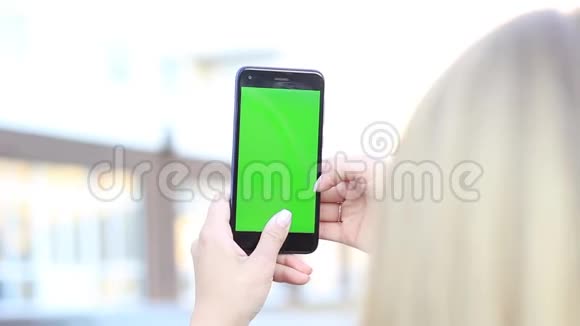 女孩手拿着一部绿色屏幕的手机Hroma键视频的预览图
