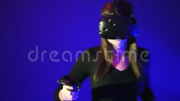 女人玩3D虚拟现实游戏在射击VR游戏中使用控制器射击穿着蓝色VR耳机的女孩视频的预览图