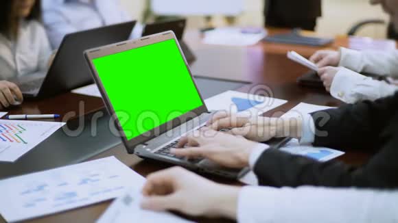 商务会议会议上商务人员在带绿色屏幕的笔记本电脑上工作视频的预览图