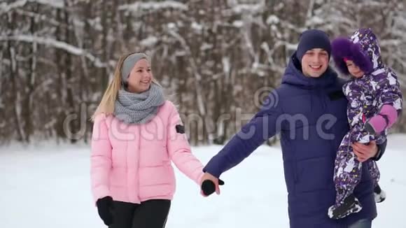 日落时幸福的家庭爸爸妈妈和两个女儿玩得很开心在下雪的冬天散步视频的预览图