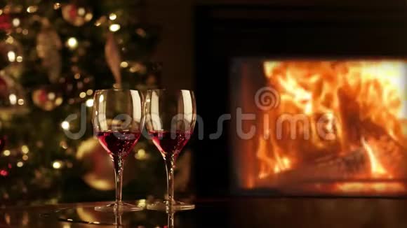 壁炉旁两杯红酒壁炉旁浪漫的圣诞夜视频的预览图