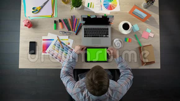有创意的人用绿色屏幕浏览平板电脑设计师观看照片视频的预览图