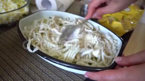女性手在铁碗里搅拌的鱿鱼沙拉视频的预览图