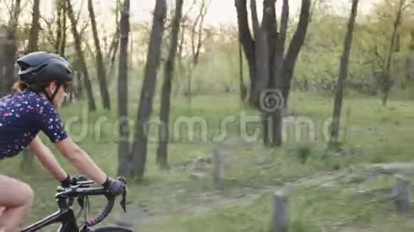 年轻漂亮的女人在公园里骑自行车为了比赛而训练自行车的概念慢动作视频的预览图