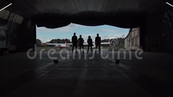 四个人站在飞机库里视频的预览图