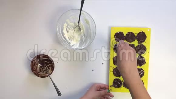 女人用巧克力覆盖里面装满了豆腐块桌子旁边是烹饪的原料从上面看时间视频的预览图