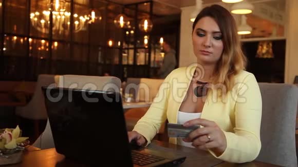 商务女性穿着商务服装使用心情愉快的信用卡进行网上购物视频的预览图