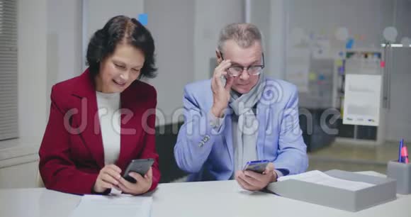 几岁的白人夫妇坐在现代银行办公室视频的预览图