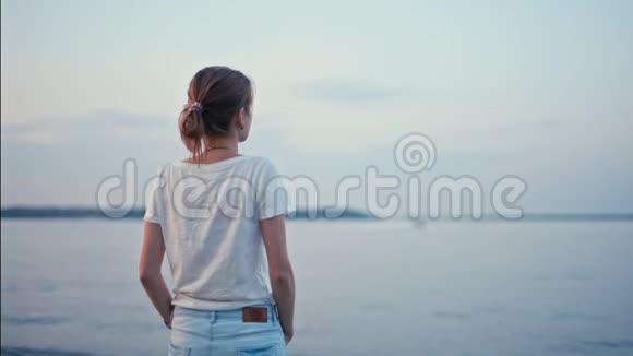 在夏日的湖岸迎接黎明时年轻的一对夫妇正在拥抱视频的预览图