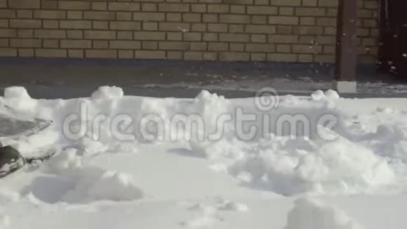 打扫卫生的人在院子里缓慢地铲雪视频的预览图