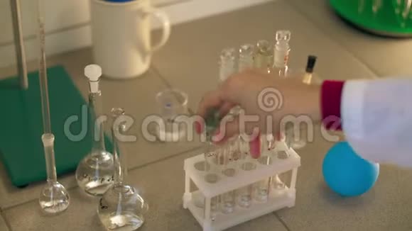 在实验室女性生物化学家用液体样品摇动试管视频的预览图