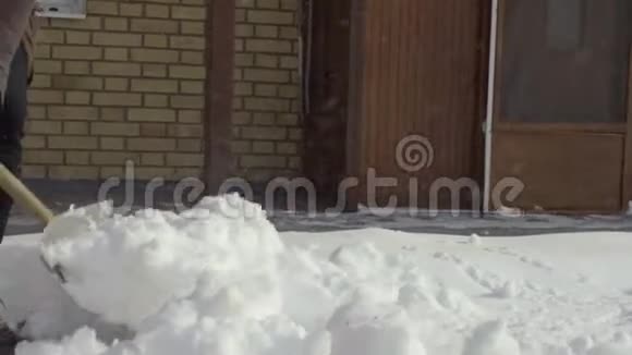 打扫卫生的人在院子里缓慢地铲雪视频的预览图