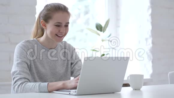 兴奋的年轻女子庆祝成功在笔记本电脑上工作视频的预览图