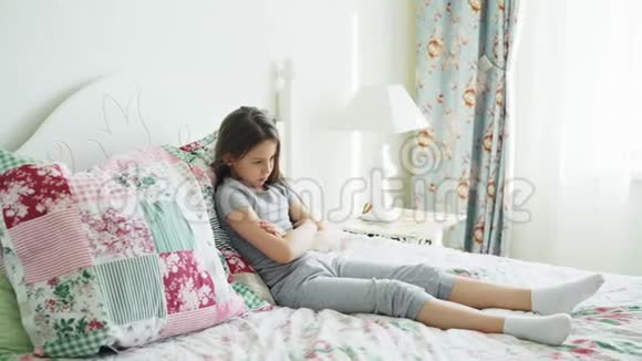 愤怒的母亲吵架责骂她心烦意乱的小女儿躺在家里明亮的卧室的床上视频的预览图