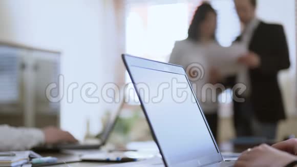 在会议上使用笔记本电脑的人在看文件的两名员工商务人员视频的预览图