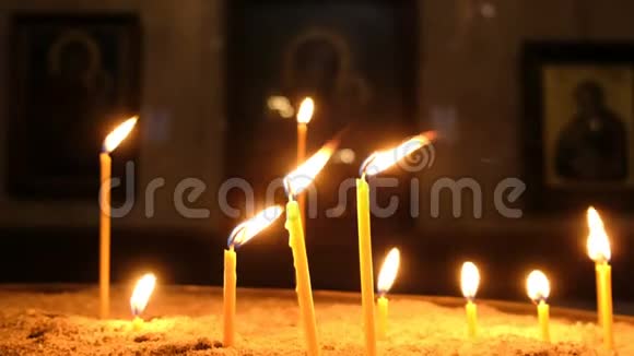 蜡烛是燃烧的站在沙滩上在东正教教堂的烛台上视频的预览图