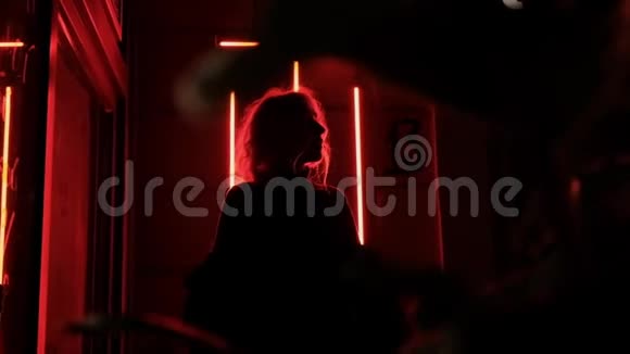 浪漫的白种人金发女人晚上在红色的霓虹灯中跳舞视频的预览图