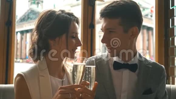 新婚夫妇在餐厅亲吻并喝香槟视频的预览图