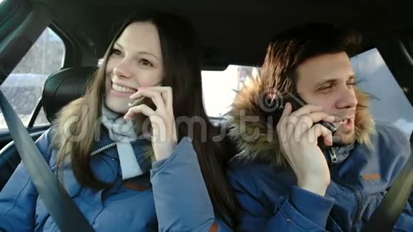 男人和女人说着手机坐在车里笑正面观点视频的预览图