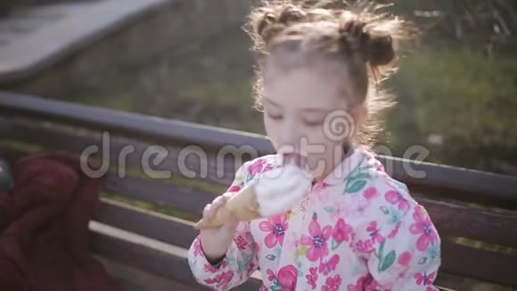 可爱的幼儿在公园里吃冰淇淋炎热的夏日视频的预览图