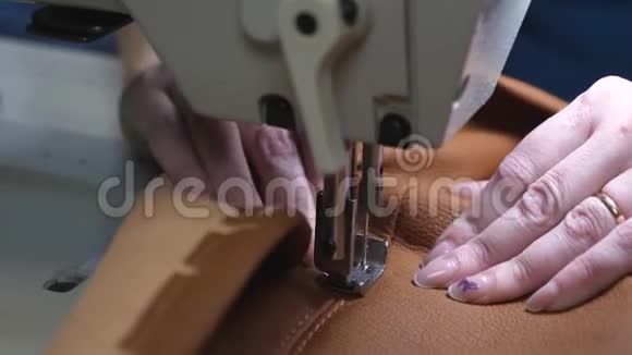 缝纫机的针在运动中女裁缝在缝纫车间缝制黑色皮革缝纫机针头视频的预览图