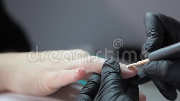专业美甲师用米黄色漆涂指甲视频的预览图