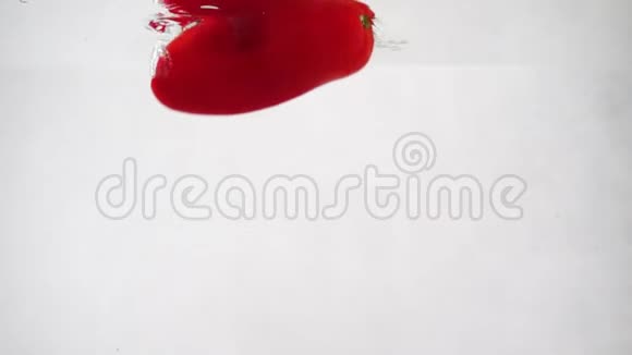 甜椒和樱桃番茄在白色背景下漂浮在水中视频的预览图