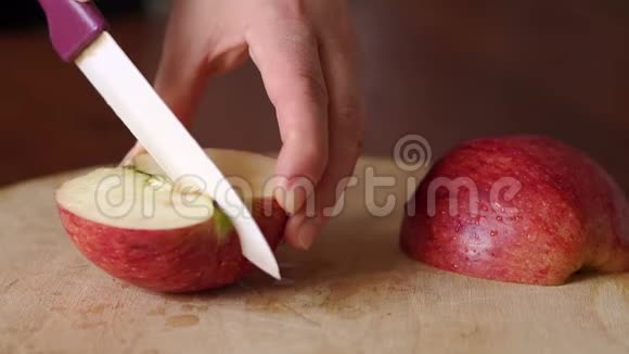 特写将红苹果切在木板上视频的预览图
