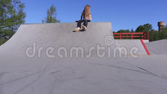 阳光明媚的小女孩在坡道上玩滑板视频的预览图