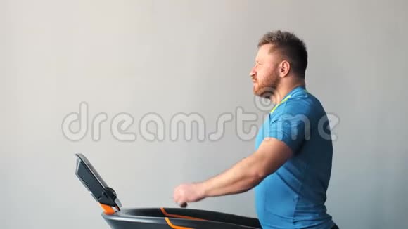 运动男在健身房跑步机上行走视频的预览图