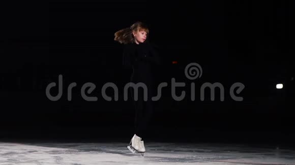 一位身穿黑色西装的女职业花样滑冰运动员单腿站立在一只的姿势旋转视频的预览图