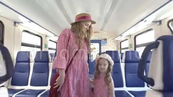 妈妈和小女儿穿着同样的衣服坐着空车散步视频的预览图