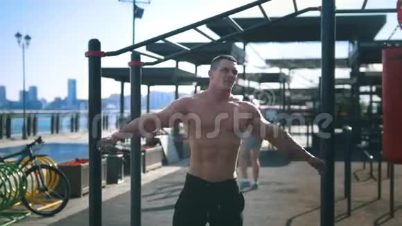 男子健美运动员在训练前做户外热身运动视频的预览图