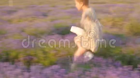 小女孩高兴地微笑着跳到户外美丽的风景草田视频的预览图