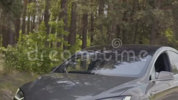 年轻夫妇在森林里慢悠悠地坐着豪华轿车视频的预览图