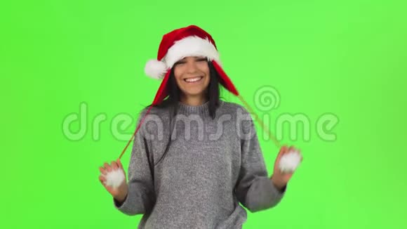 一个迷人的圣诞老人女孩在工作室里玩视频的预览图